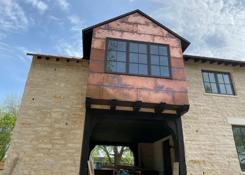 Copper metal panel facade on a stone building for Skylight Installation in Harrietstown