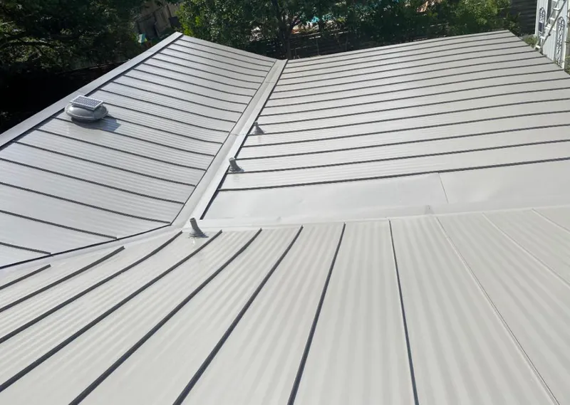 Solar attic fan installed on a metal roof for Roof Ventilation in Harrietstown